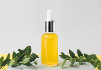 Bottle of healthy essential oil on grey background