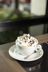 Coffee with cream served on a wooden table in the restaurant