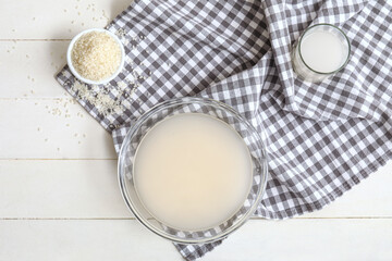 Bowl with tasty rice milk and ingredients on kitchen table
