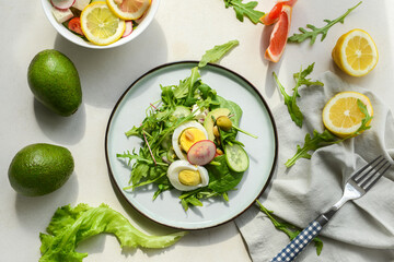 Plate with healthy salad with egg on light background