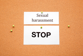 Paper sheets with text STOP SEXUAL HARASSMENT on color background