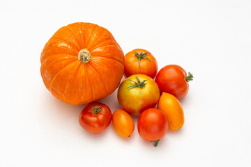 Ripe vegetables - pumpkin and tomatoes on a white background. Red and orange vegetables are a source of carotene