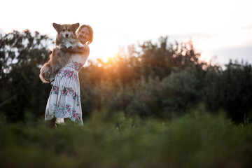 girl holding a corgi dog