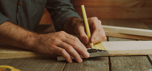 Close up of worker measuring wooden detail on the table