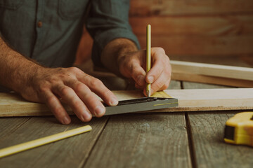 Close up of worker measuring wooden detail on the table