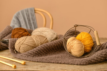 Knitting yarn, needles and plaid on wooden table