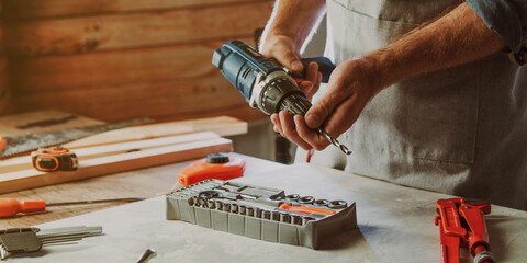 Close up of worker changing a drill for screwdriver