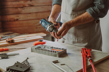 Close up of worker changing a drill for screwdriver