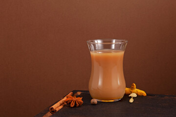 Karak tea or Masala chai on brown background. Selective focus, copy space