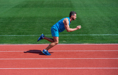 athletic muscular man running in sportswear on stadium track, finish