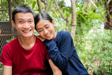 Asian young  couple in love embracing sitting at the home