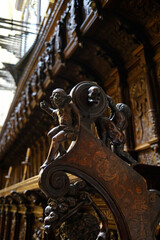 Armrest in carved wood with the figure of Sisyphus
