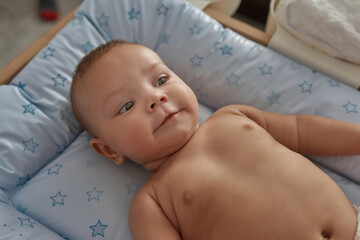 Sweet naked newborn baby on blue background