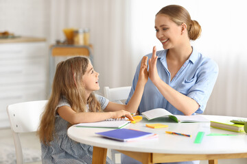 Little girl and her mother giving each other high-five at home