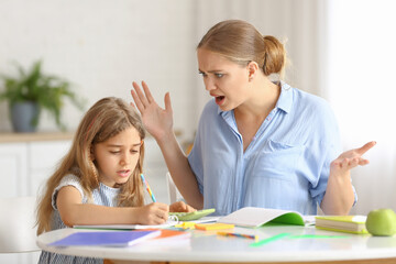 Fototapeta premium Little girl with her mother doing lessons at home