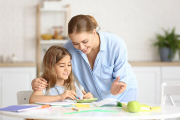 Fototapeta premium Little girl with her mother doing lessons at home