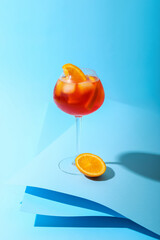 Glass of Aperol spritz cocktail on color background