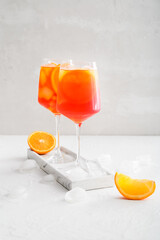 Glasses of Aperol spritz cocktail on light background