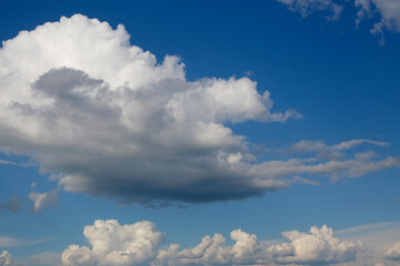 Large white cloud on the blue sky. Sunny sky and white clouds.