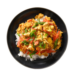 Thai dish Gai Pad Pongali with chicken, eggs, spicy, yellow thai curry paste, tomatoes on rice in black bowl isolated on white background. Pan-Asian cuisine. Thai Stir Fried food and meal.