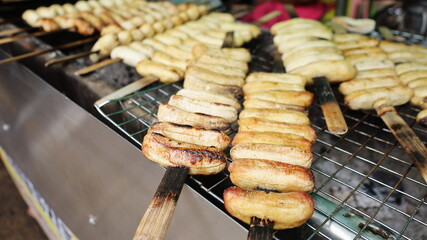 Grilled Banana Skewers. Roasted banana lightly grilled street food Traditional Thai desserts sold in local markets. selective focus