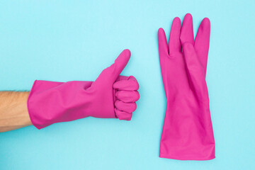 Man in a protective rubber glove. Symbol like. Rubber gloves for cleaning on a blue background. Flat lay.