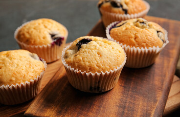 Tasty blueberry muffins on table, closeup