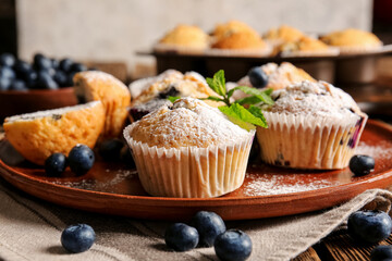 Plate with tasty blueberry muffins on table, closeup