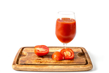 Fresh tomato juice and tomatoes on wooden board.