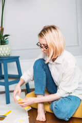 Young woman artist is painting at home in a creative studio setting. 