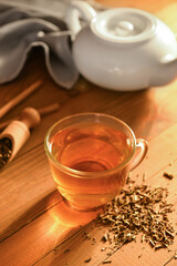 Cup of tasty hojicha green tea on wooden background