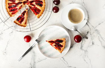 Composition with tasty plum pie and cup of coffee on light background