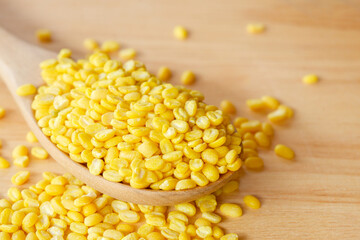 Close-up of Peeled split mung bean on spoon wooden. Healthy food concept.