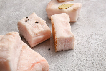 Pieces of salted lard on light background, closeup