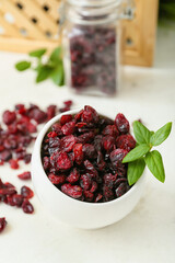 Bowl with tasty dried cranberries on table, closeup