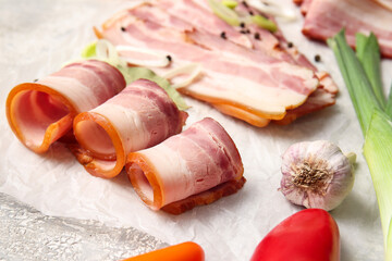 Slices of tasty smoked bacon on light background