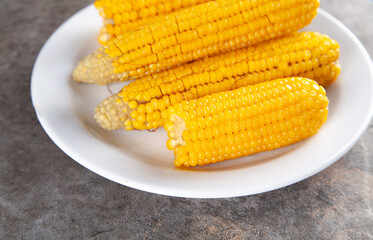 Boiled corn on a white plate.
