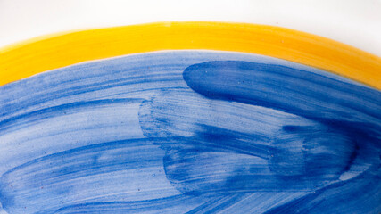 Brochazos de esmalte amarillo y azul en cerámica
