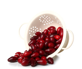 Colander with ripe dogwood berries on white background