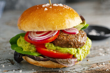 Burger with meat patty and avocado sauce