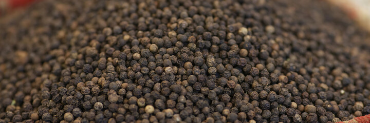 Black round pepper on counter of market