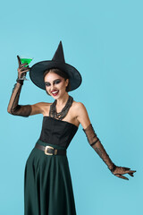 Beautiful young woman in Halloween costume of witch on color background