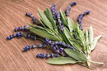 Sage leaves, lavender and rosemary on a wooden background. Fresh spicy herbs.