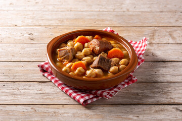 Traditional Spanish cocido madrileño in bowl on rustic wooden table
