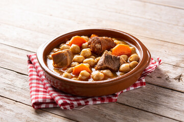 Traditional Spanish cocido madrileño in bowl on rustic wooden table