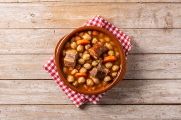 Traditional Spanish cocido madrileño in bowl on rustic wooden table