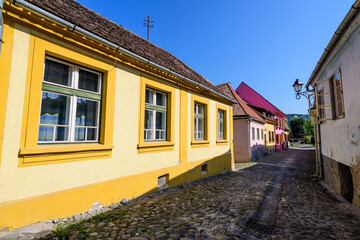 Old colorful painted houses in the historical center of the Sighisoara citadel, in Transylvania (Transilvania) region of Romania, in a sunny summer day.