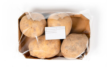 Freshly harvested potatoes in a labeled pack on white background