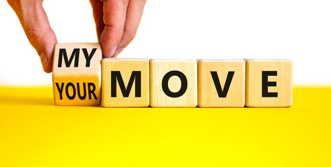 My or your move symbol. Businessman turns a wooden cube and changes words 'your move' to 'my move'. Beautiful yellow table, white background. My or your move and business concept. Copy space.