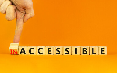 Accessible or inaccessible symbol. Businessman turns a wooden cube, changes the word Inaccessible...